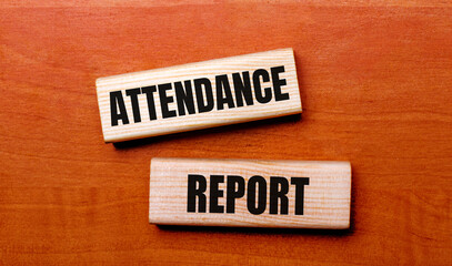 On a wooden table are two wooden blocks with the text question ATTENDANCE REPORT