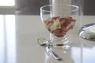 A bowl of strawberries, whipped cream and chocolate