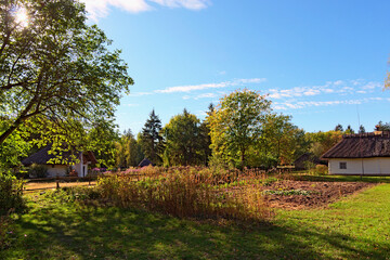 Picuresque rural landscape view of ancient Ukrainian village. Reconstruction of an ancient clay house with thatched roof, front yard with outbuildings