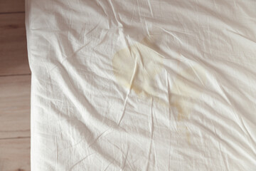 Image of pee's child on the white bed sheet. Cause stains and dirty on the mattress.
