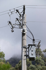 Electricity rural wooden utility pole with cables and insulators in Melbourne against a hazy sky