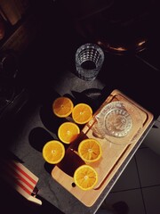 Oranges cut in half with a glass and juice press
