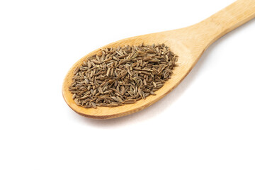 Closeup of cumin seeds on a wooden spoon isolated over white background