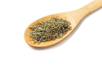 Closeup of dried rosemary on a wooden spoon isolated over white background