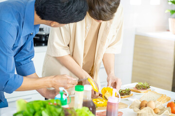 Asian young men lover LGBTQ cooking in the kitchen work from home 