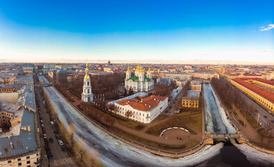 Fototapeta na wymiar Aerial top view to St. Nicholas Naval Sea Cathedral in sunny day. Panorama of evening historical city center. Orthodox church located on banks of Kryukov and Griboyedov canal. Saint Petersburg. Russia