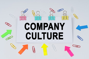 On the table there are paper clips and directional arrows, a sign that says - Company Culture