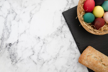 Easter eggs, bread, ciabatta, udon, pasta, flour products on a granite, stone background. Top view. Bright Resurrection of Christ