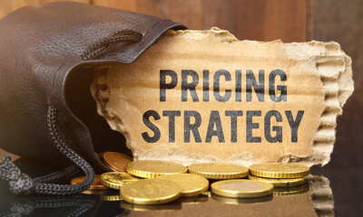 On the table is a bag of money from which sticks out cardboard with the inscription - PRICING STRATEGY