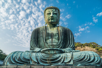 The Great Buddha or Daibutsu at Kotoku-in Buddhist Temple. A large bronze statue found in Kamakura, Japan. Photographed with a bright blue sky.