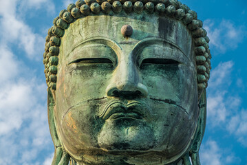 The Great Buddha or Daibutsu at Kotoku-in Buddhist Temple. A large bronze statue found in Kamakura, Japan. Photographed with a bright blue sky.