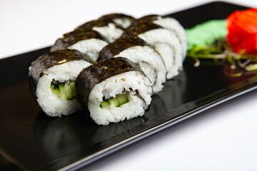Japanese food rolls in plastic box. Sushi set in a plastic package close up isolated on a white background. Sushi for take away or sushi delivery.