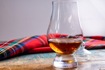 One dram of scotch whisky with red scottish tartan on background