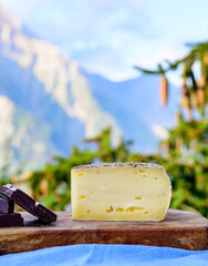 Cheese collection, French tomme de savoie or tome des bauges cheese and dark chocolate served...