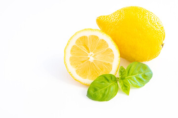 Whole yellow lemon fruit with half lemon isolated on white background with leaf and copy space