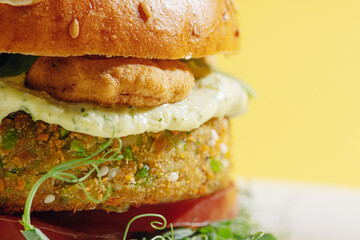 bright fresh veggie burger without gluten and meat. burger on a yellow background in a white plate