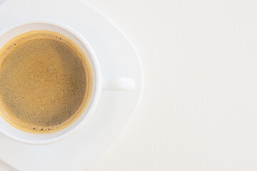 Close up top view of a white porcelain cup of coffee isolated on white background with copy space