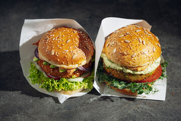 two bright fresh veggie burger without gluten and meat. burger on a gray stone background. serving burgers in a cafe or restaurant