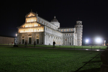 Fototapeta na wymiar Piazza Miracoli in Pisa seen at night between monuments such as the tower and the solitude of the global pandemic in the dark