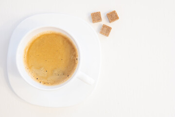 Cup of coffee on saucer with three sugar cubes isolated on white background and copy space for text