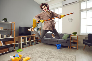 Funny positive housewife cleaning her house, fooling around and having fun. Happy energetic woman...