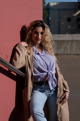 A young woman in a shirt and pants walks through the city of Barcelona while drinking coffee, dancing and singing while enjoying the sun