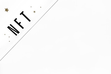 NFT inscription on white  background. Close-up, top view, copy space.