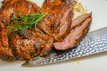Marinated steak sliced in pieces with cilantro in a cutting board
