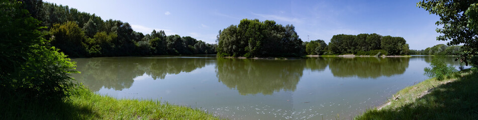 Fototapeta na wymiar Green lagoon and woods in the italian countryside 
