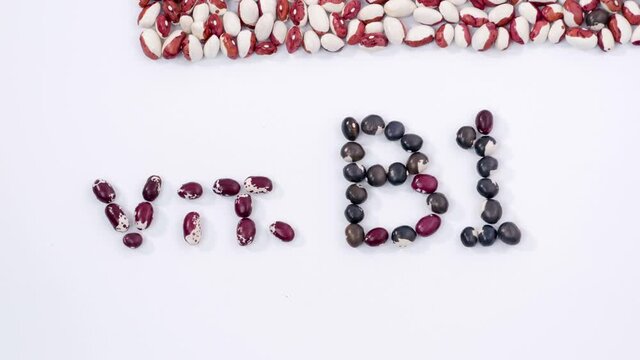 Kidney beans form word vit B1 in middle of white background with top and bottom frame healthy diet vitamins and minerals health care protein crops. Close up 4K Ultra HD.