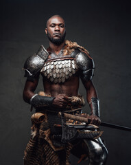 Powerful and handsome authentic soldier wearing armor with axe