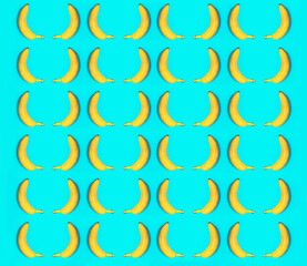 Top view, of rows of yellow bananas on the blue background.