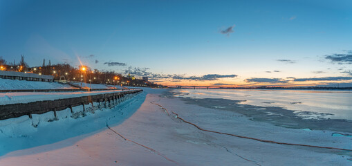 The embankment in Perm in winter, the Kama River in the evening twilight.