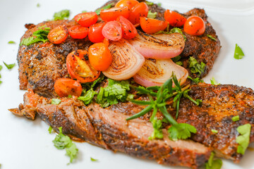 Sliced grilled beef barbecue carne asada steak with cilantro on cutting board on a gourmet dish plate