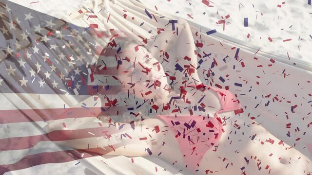 American flag waving and confetti falling against caucasian wpman laying on hammock at the beach