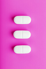 Ecstasy pills in a row on a pink background, isolate.
