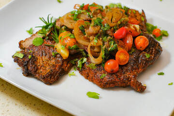 Sliced grilled beef barbecue carne asada steak with cilantro on cutting board on a gourmet dish plate