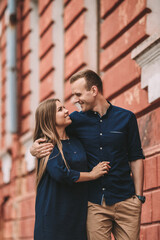 Happy couple in love walks the city streets together. A lovely couple on the old narrow streets of the city. Lifestyle of smiling people. Family relations concept