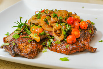 Sliced grilled beef barbecue carne asada steak with cilantro on cutting board on a gourmet dish plate