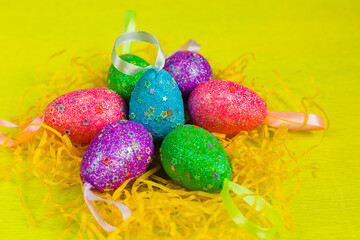 colorful, hand-painted, pastel Easter eggs on a bright, yellow, spring background