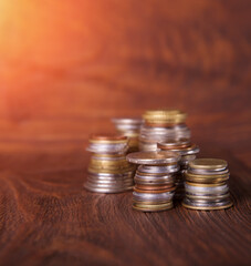 Coins on the background of mahogany. Stacks of coins of different nominal value. Concept - advertising about the bank or finances company.