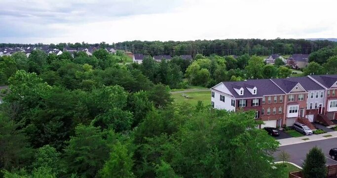 Drone shot through trees revealing suburban sprawl