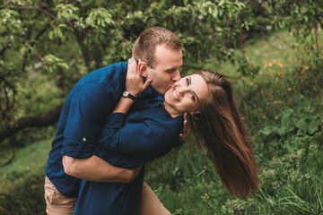 Fototapeta premium Portrait of a happy couple have fun in the spring garden. Strong family relationships of a couple in love