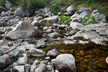 Naklejka na ściany i meble River flowing through the stones