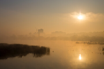Fog over the river and city. Misty morning in the river. Foggy sunrise over the lake