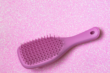 Pink hairbrush on pink background