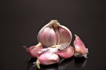 The head of garlic on a black kitchen counter.