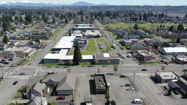 Cinematic aerial drone panning clip of downtown Marysville, by the I-5 freeway, a distant suburb, bedroom community North of Seattle on the shores of Puget Sound in Washington