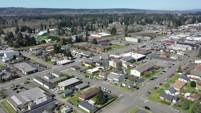 Cinematic aerial trucking drone clip of downtown Marysville, by the I-5 freeway, a distant suburb, bedroom community North of Seattle on the shores of Puget Sound in Washington