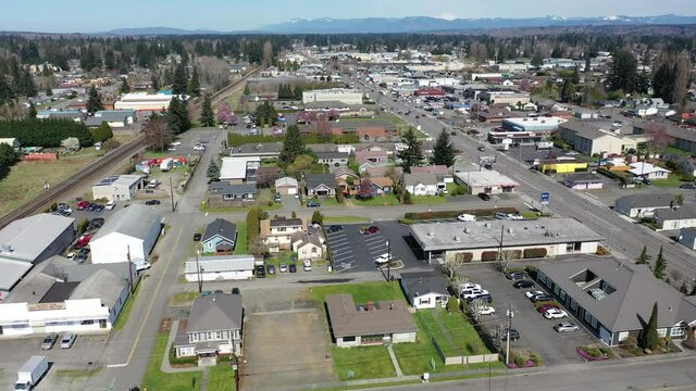 Cinematic aerial drone panning shot of downtown Marysville, by the I-5 freeway, a distant suburb, bedroom community North of Seattle on the shores of Puget Sound in Washington